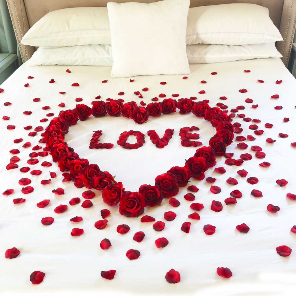 Romantic hotel bed with rose petals