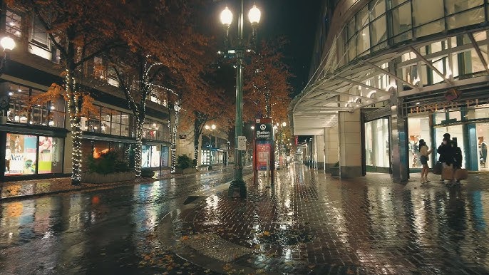 Rainy Portland street with glowing café windows and umbrellas